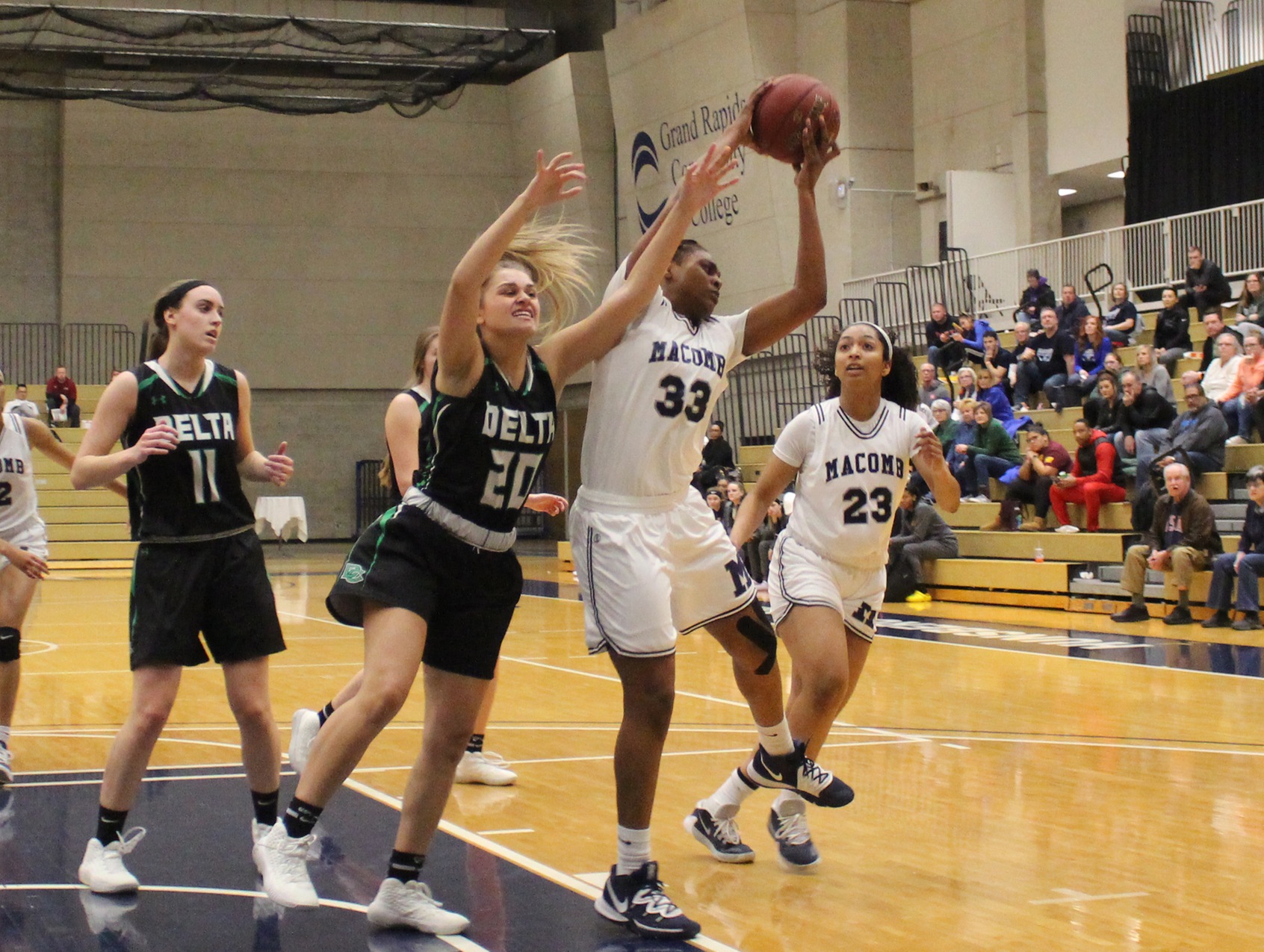 Macomb's Lauren Wynn grabs a rebound against Delta College